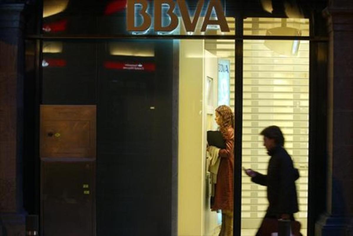 Una mujer utiliza un cajero de una oficina del BBVA en Barcelona. Una mujer utiliza un cajero de una oficina del BBVA en Barcelona.