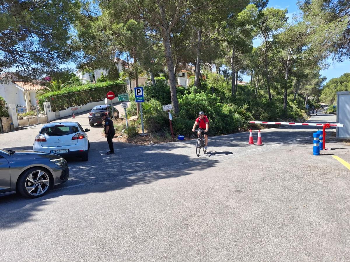 El controlador desvía a los coches en el inicio de la carretera que baja a la Granadella