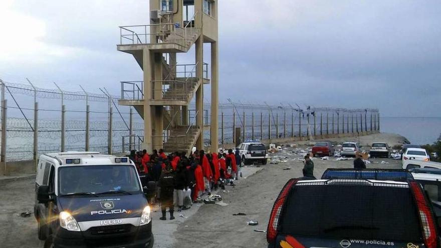 Agentes de la Policía y de la Guardia Civil controlan a un grupo de subsaharianos, ayer, en Ceuta. // Efe