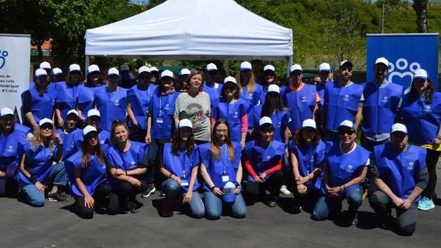 Los concejales Ana Taboada y Rubén Rosón posan con los setenta y cinco nuevos voluntarios del albergue de animales.