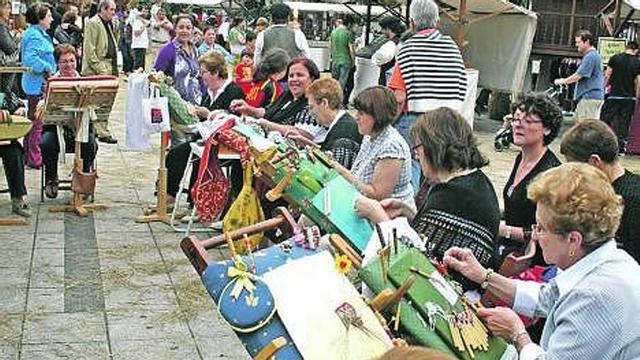 Las encajeras de Candás, en plena demostración; a la derecha, el borracho, uno de los personajes de «Clarín», ayer, en la inauguración del mercado.