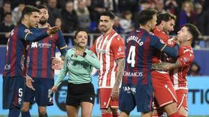 Los jugadores del Huesca y del Almería discuten en presencia de Marta Huerta el pasado viernes.