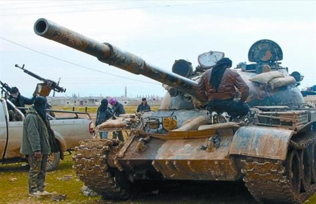 Uns rebels observen untanc ocupat pels desertorsde l’Exèrcit a Al-Qusair. Uns rebels observen untanc ocupat pels desertorsde l’Exèrcit a Al-Qusair.