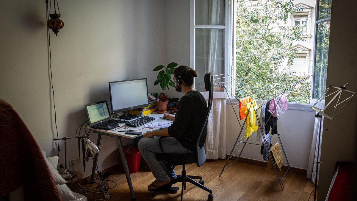 Un hombre teletrabaja en su domicilio.