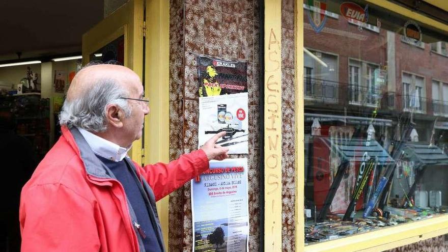 El dueño de la armería muestra la pintada de la fachada del establecimiento.