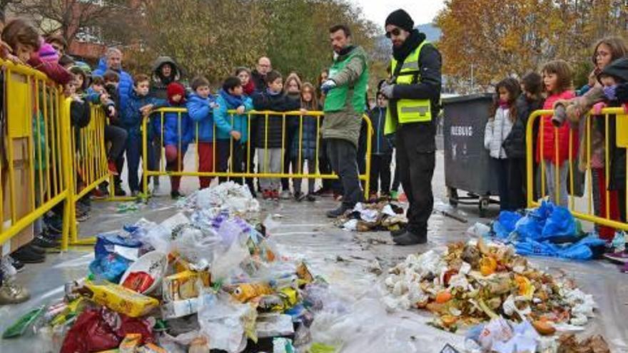 Alumnes de primària de Súria observant les deixalles d&#039;un contenidor a la plaça de Sant Joan