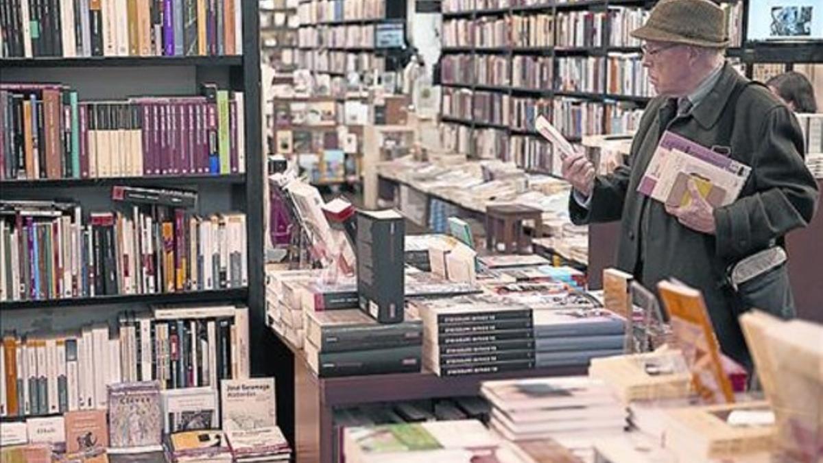 Un lector curiosea entre los expositores de la Librería Central.