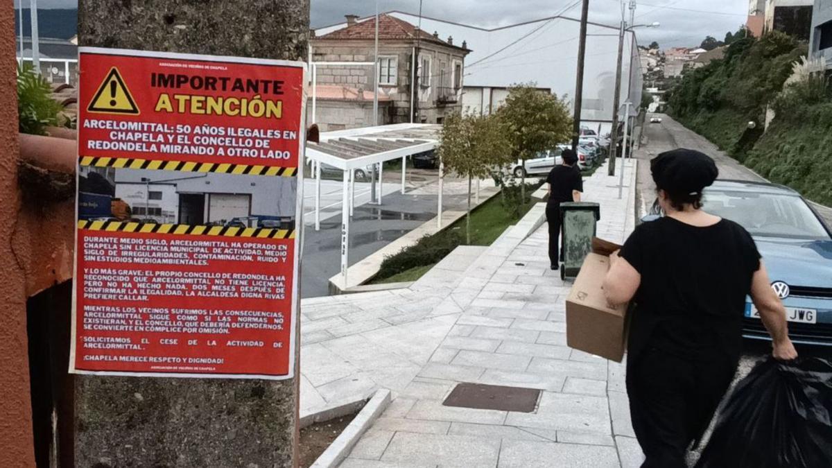 Un cartel advierte de las molestias que causa la empresa en Chapela, con la nave al fondo, ayer.