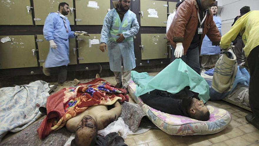 Diversos forenses revisen els cossos d&#039;algunes víctimes del darrer bombardeig sobre Bengasi.
