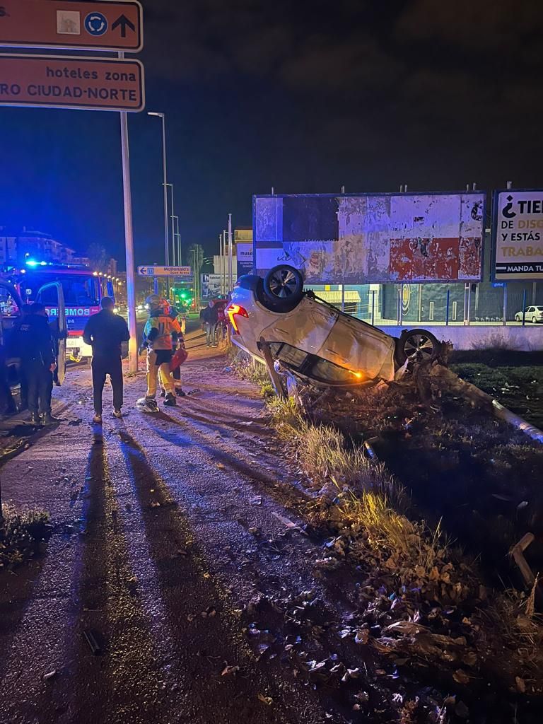 Bomberos junto al vehículo siniestrado.