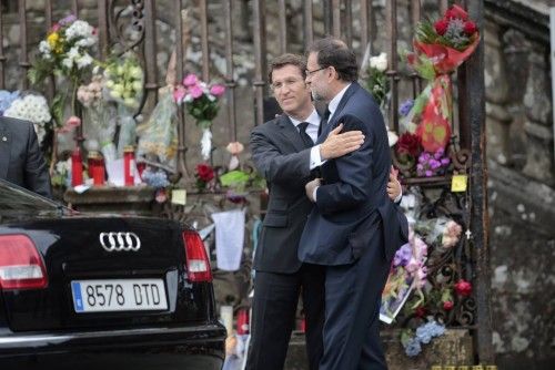 Spain's Prime Minister Rajoy is embraced by Galician regional president Nunez Feijoo as they arrive to attend a funeral service in memory of the victims of the July 24, 2013 train crash, at the Cathedral of Santiago de Compostela