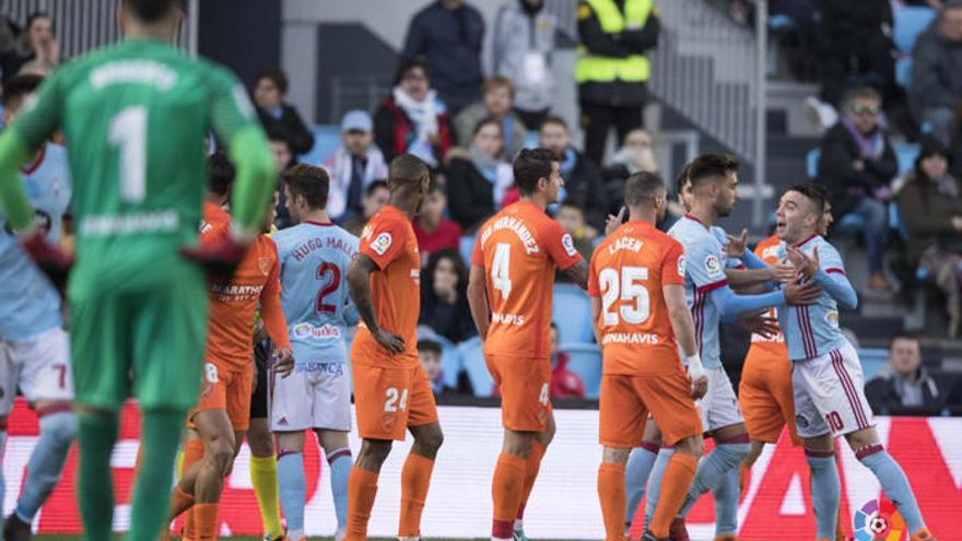 Los jugadores del Málaga CF discuten con Iago Aspas en una acción del partido de ayer.