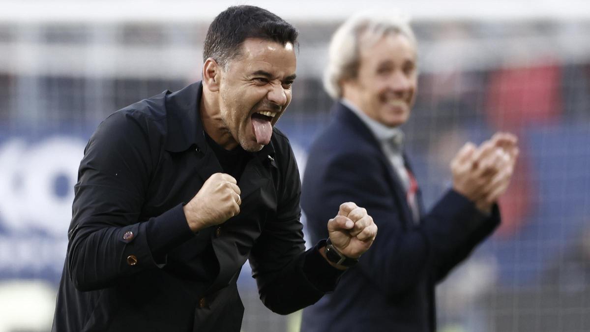 Míchel festeja el triunfo del Girona en Pamplona ante la mirada de David Torras, jefe de comunicación del club.