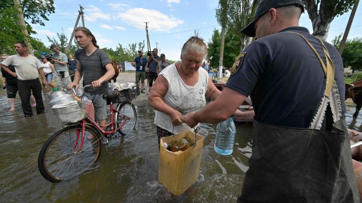 Los voluntarios entregan alimentos a los residentes locales en un área inundada, en medio del ataque de Rusia a Ucrania, en Kherson