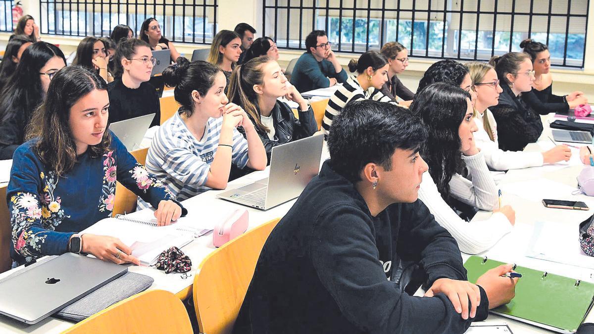 Alumnado de la Universidad de Santiago atiende a las explicaciones de un profesor durante una clase