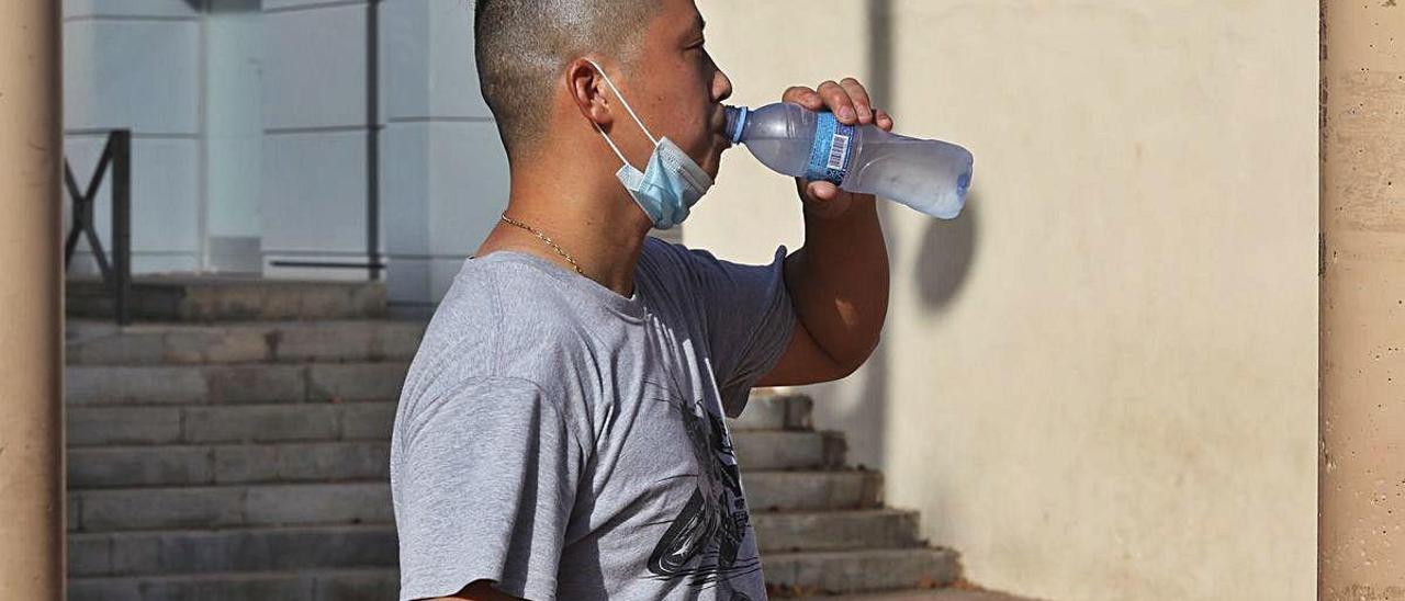 Un vecino de Elche bebe agua en la calle para soportar las altas temperaturas, ayer.