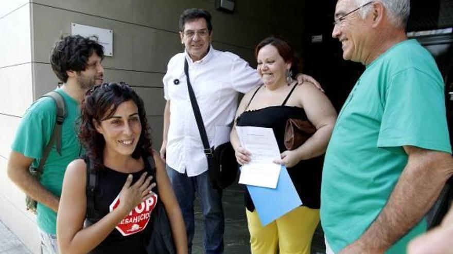 Raquel Batllés, en el centro, muestra el contrato de alquiler junto a los miembro de la PAH.