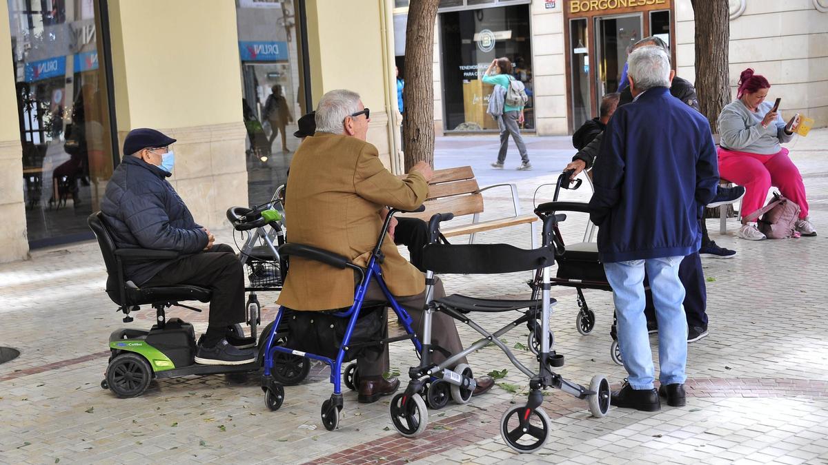 Un grupo de jubilados conversa en una plaza de Elche.