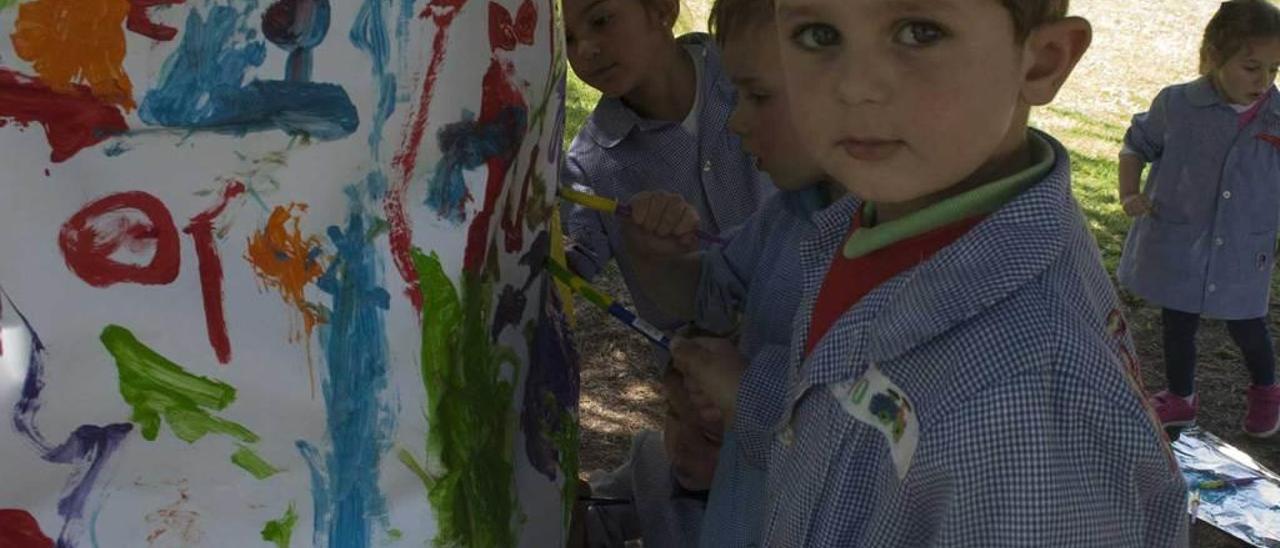 Los escolares de Educación Infantil pintando los árboles del centro.