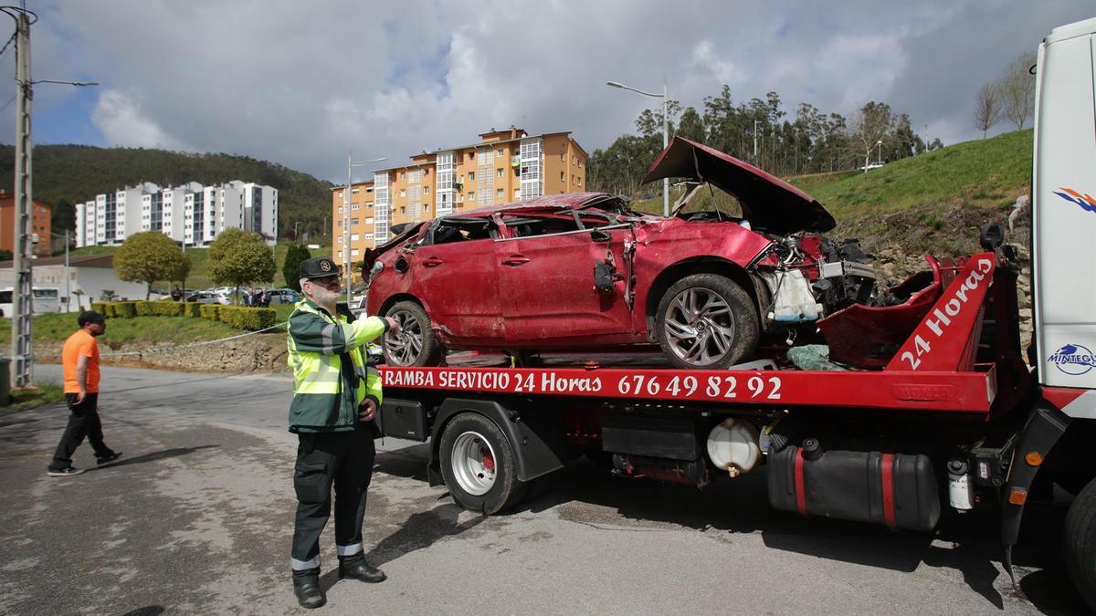 Un Guardia Civil vigila la retirada del coche siniestrado en el accidente de Xove