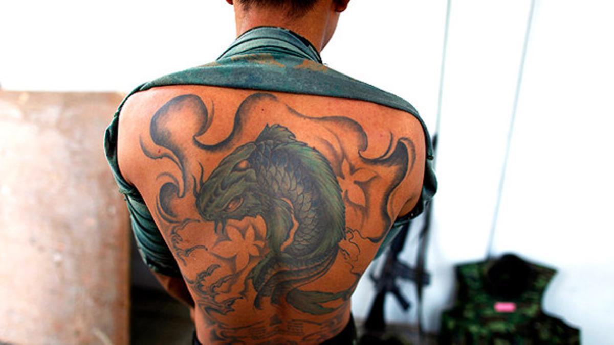 Un soldat tailandès es descobreix l’esquena després d’haver patrullat pels carrers de Bangkok.