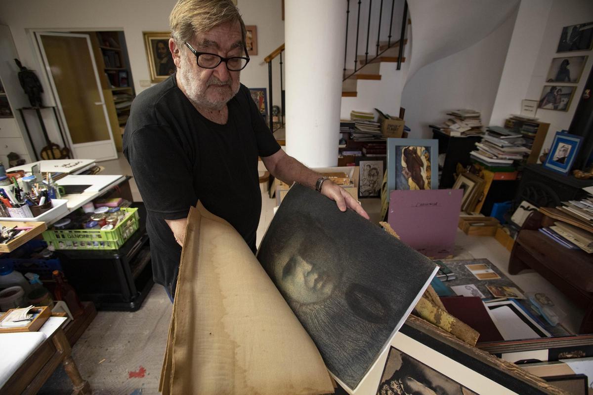 El pintor Joan Ramos muestra algunas de las obras dañadas por las filtraciones de agua en su estudio.