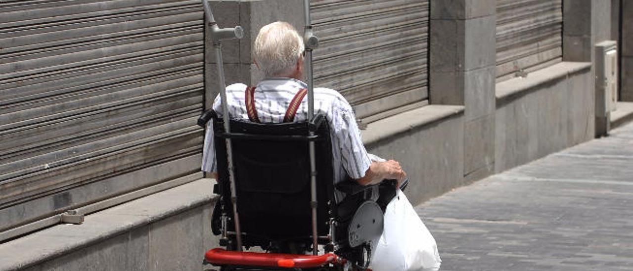 Un señor mayor circula por la capital gran canaria en silla de ruedas.