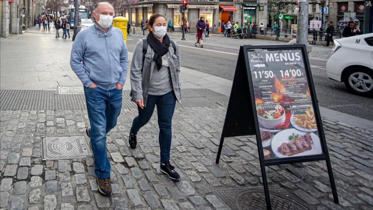 Dos personas con mascarillas por temor al coronavirus en el centro de Madrid