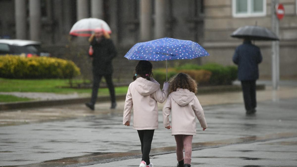 Dos niñas se protegen con un paraguas de la lluvia hoy en Pontevedra