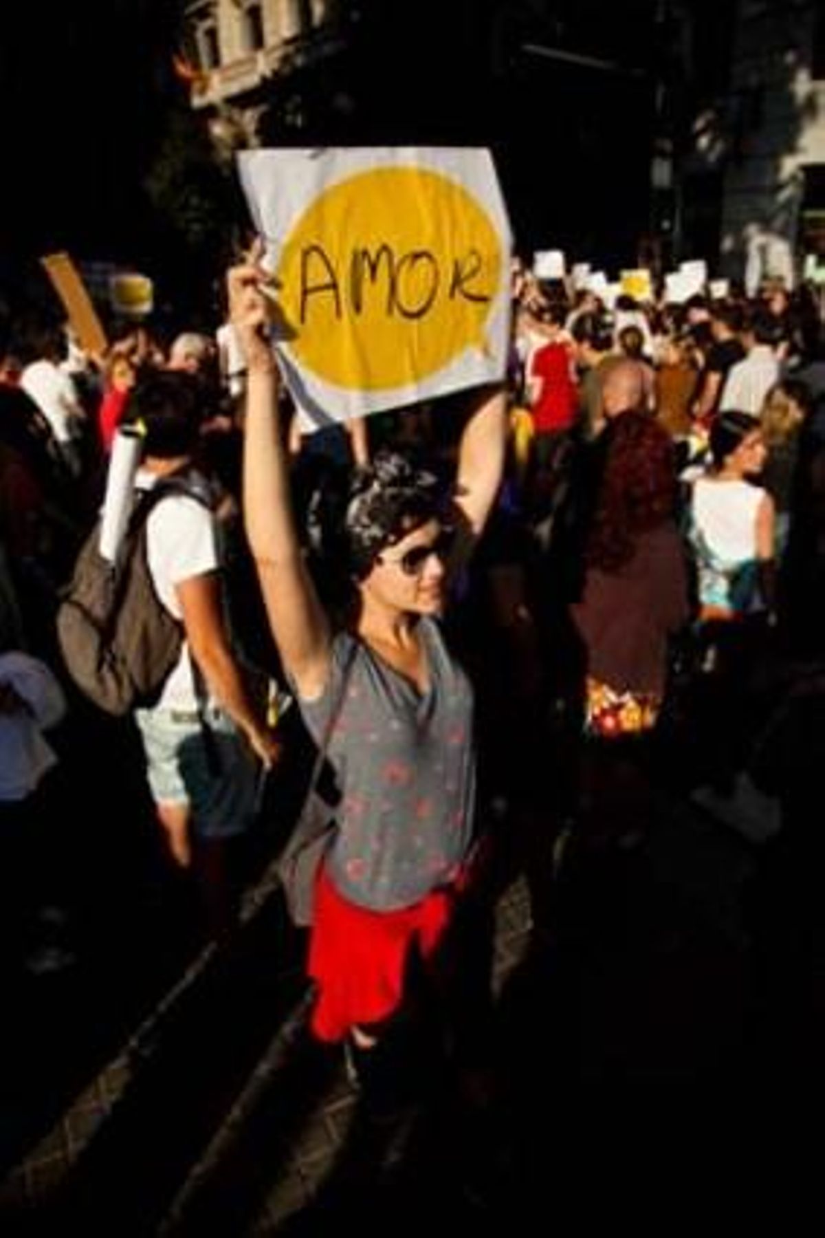 Una noia sosté un cartell al pas de la marxa de protesta pel carrer de Fontanella.