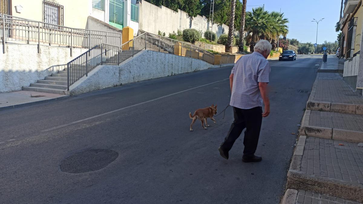 Un hombre camina por la calle de los depósitos de agua de la localidad de Lucena.