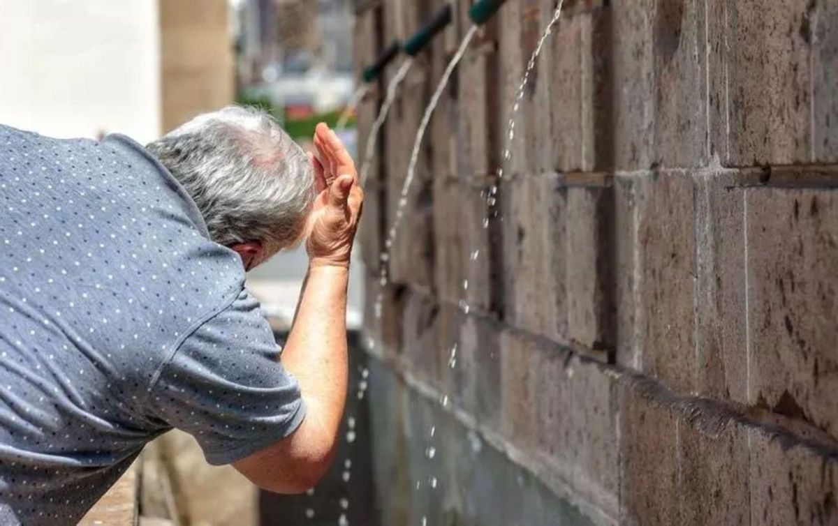 Un hombre se refresca en una pequeña fuente en Santa Cruz durante una ola de calor. | | MARÍA PISACA
