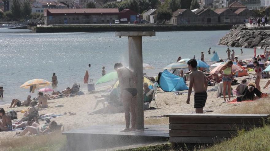 Personas disfrutando del baño en la playa de Rodeira.