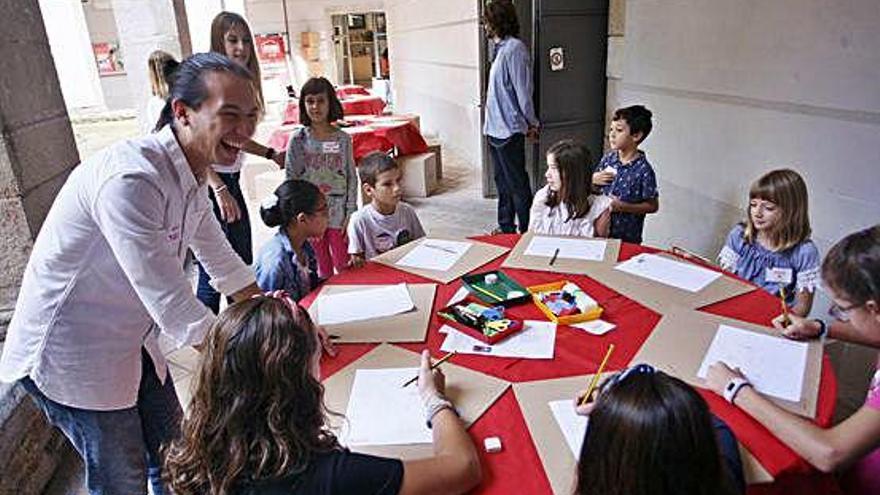 Un grup d&#039;infants i voluntaris participant en el taller, diumenge, al claustre de La Mercè.