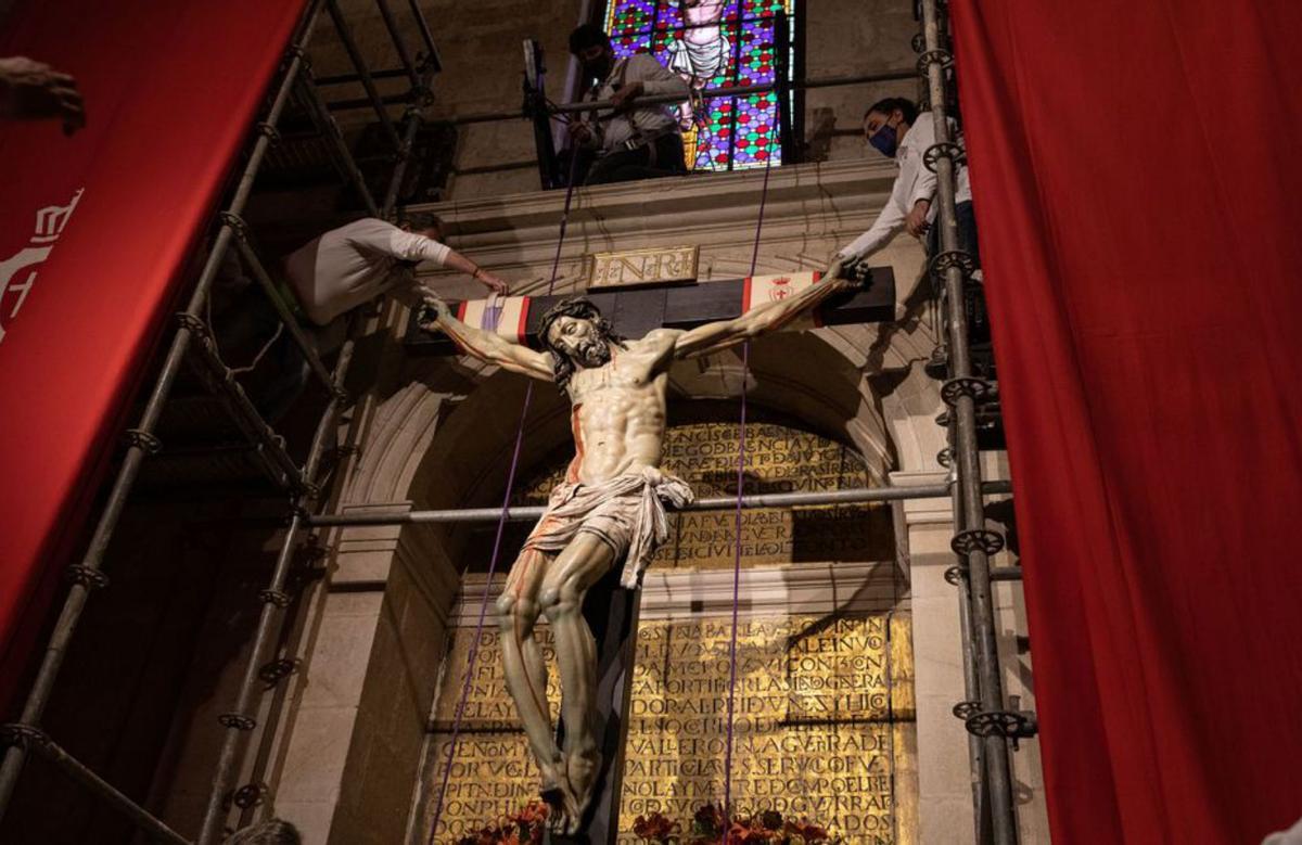 Los cargadores colocan las sogas de las que se ayudarán para bajar la talla del altar de la capilla de la Catedral. | Ana Burrieza