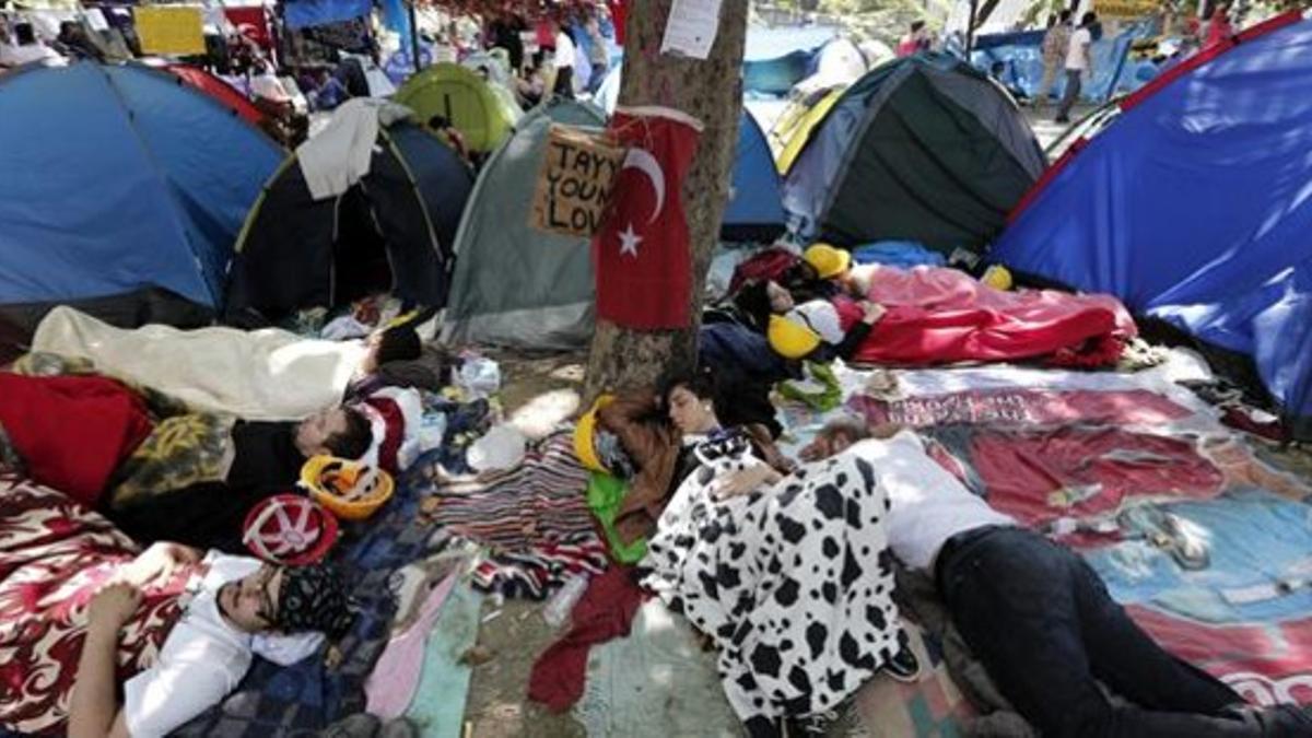 Jóvenes turcos duermen al aire libre en el parque Gezi, junto a la plaza Taksim, este jueves.