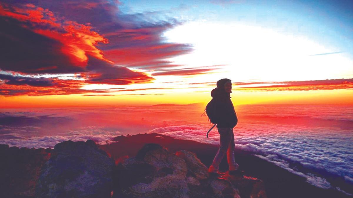 Un senderista en la cima del Teide durante el amanecer.