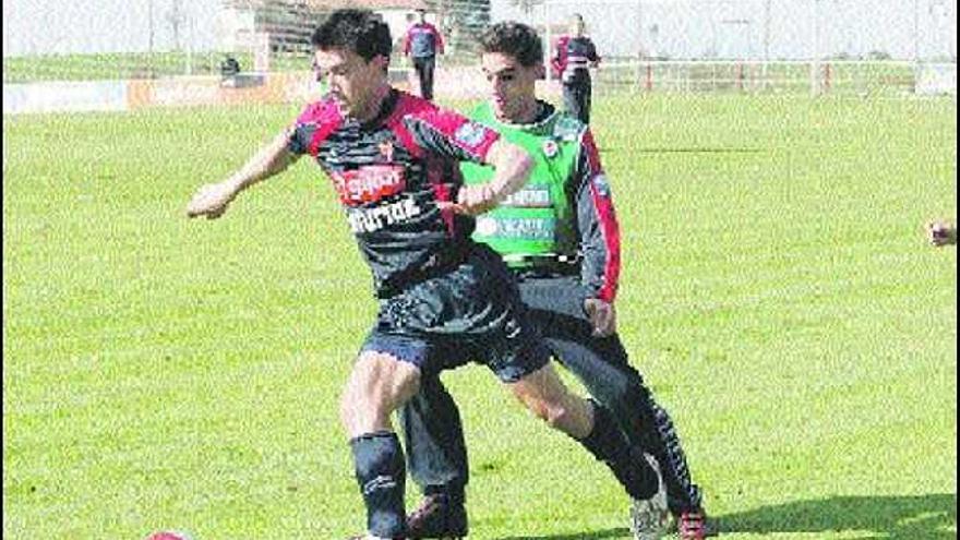 Kike Mateo, protegiendo el balón ante la presión de Marcos Landeira en el entrenamiento de ayer.