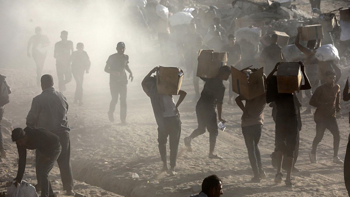 Archivo - Palestinos recogen paquetes con ayuda humanitaria en Gaza