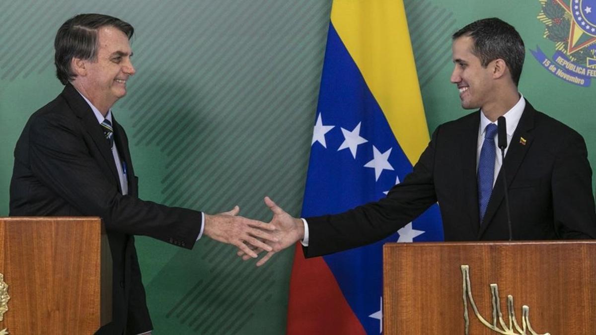 El presidente de Brasil, Jair Bolsonaro (izquierda), y el líder opositor y autoproclamado presidente venezolano, Juan Guaidó, se saludan durante el encuentrpo que mantuvieron este jueves en Brasilia.