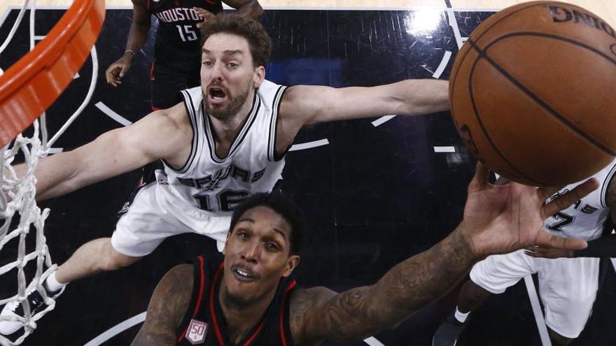 Gasol trata de taponar a un jugador rival.