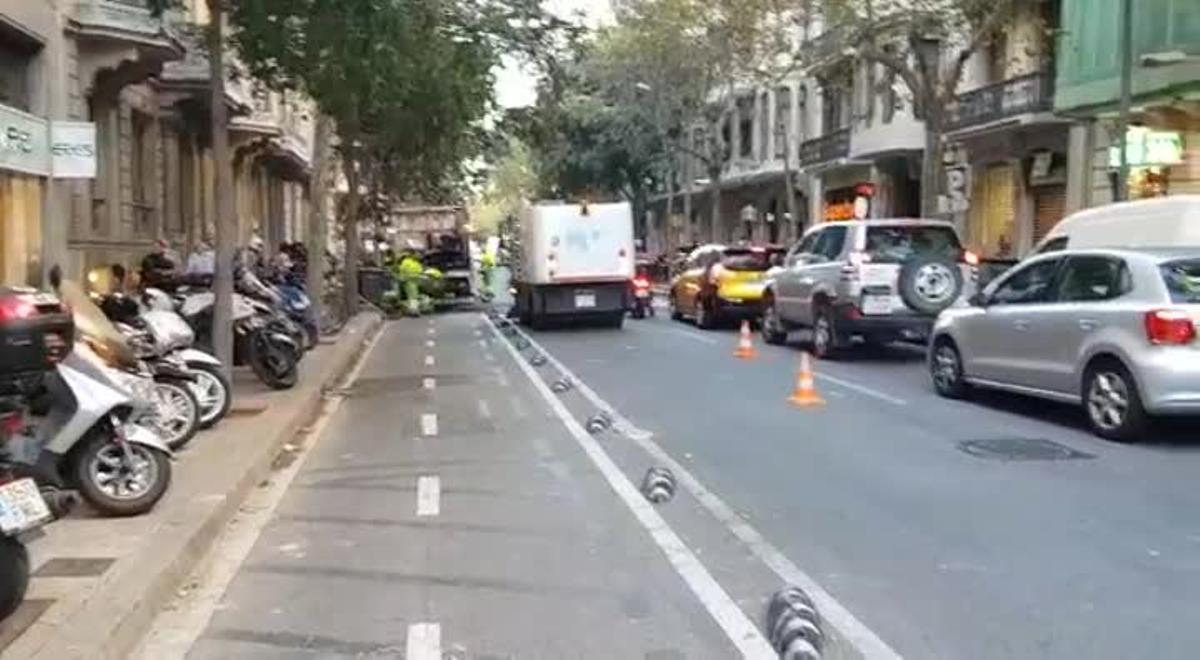 Retirada de contenedores quemados y limpieza de cera de la calzada en paseo de Gràcia con Provença.