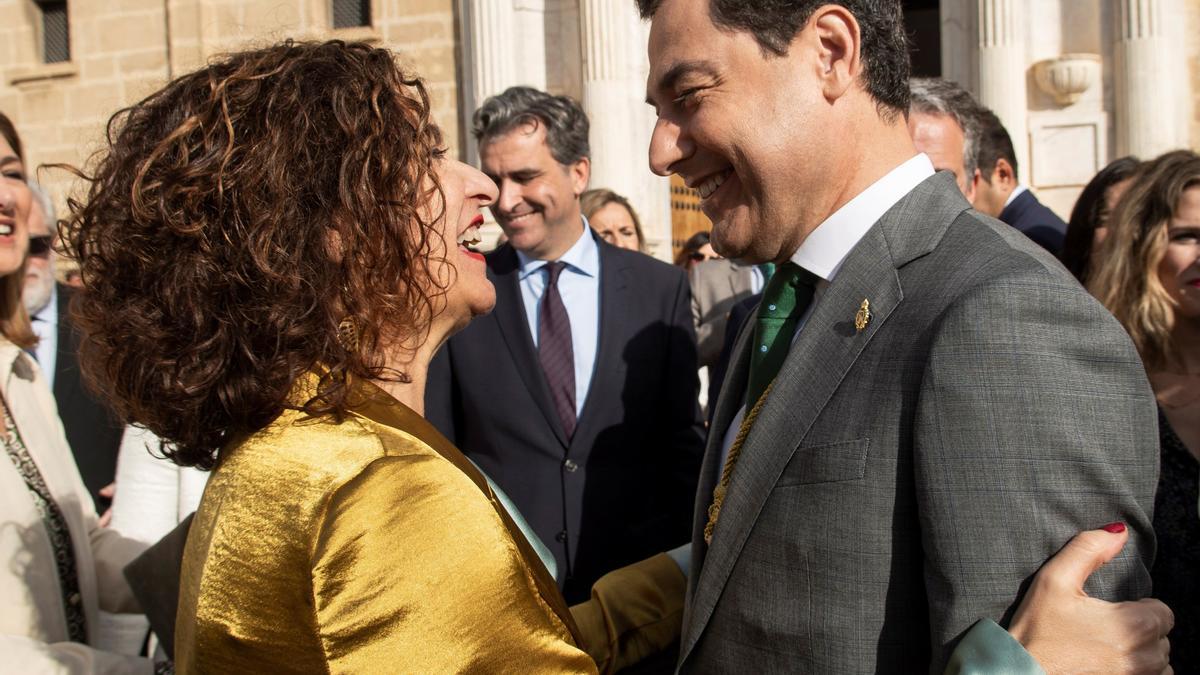 La ministra de Hacienda y el presidente andaluz se saludan en el Parlamento en una festividad del Día de Andalucía.