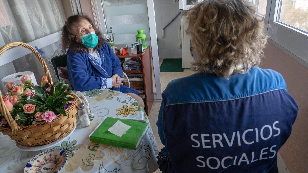 Una trabajadora de Servicios Sociales con una vecina de Cartagena vulnerable.