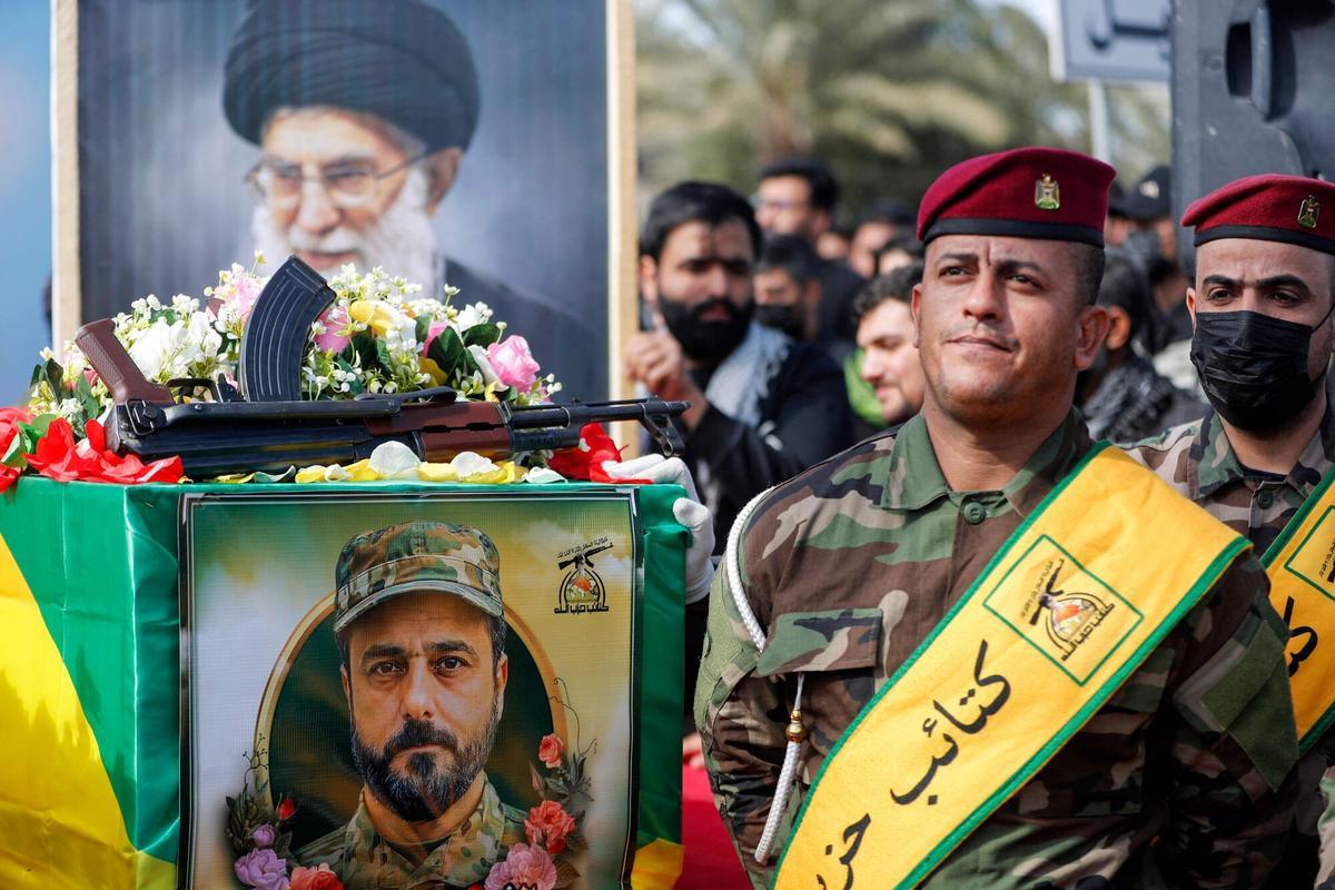 Bagdad, 5 mar 2026. Un asistente sostiene un retrato del líder supremo iraní muerto, el ayatolá Alí Jameneí, durante el cortejo fúnebre de miembros de las Brigadas de Hezbolá (Kataeb Hezbolá), milicia iraquí proiraní, muertos en un ataque el día anterior. El grupo, respaldado por Teherán, afirmó que uno de sus comandantes murió en un bombardeo en el sur de Irak.