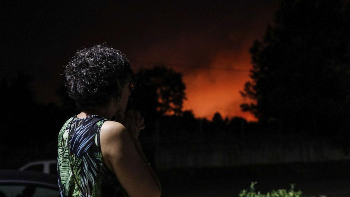 Una vecina de Ferreras de Abajo contempla con preocupación el fuego mientras ordenan desalojar su pueblo. | Emilio Fraile