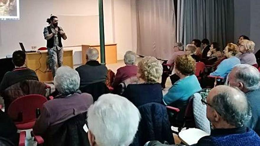 Carlos Adeva, de pie, explica a los alumnos de la Universidad de la Experiencia el contenido de su charla.