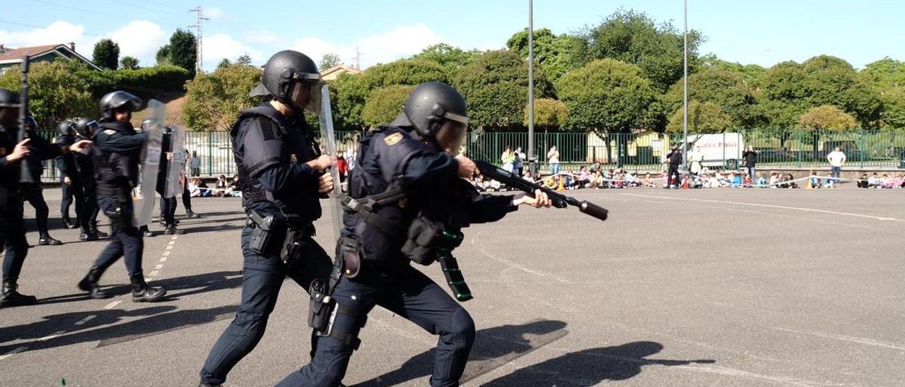 Varios miembros de la Unidad de Intervención Policial (UIP) simulan una carga en el patio del colegio de La Carriona.