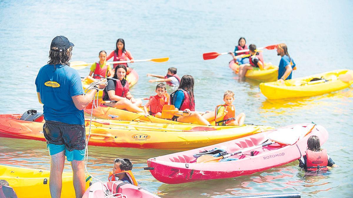 Monitores enseñan a sus alumnos a remar.