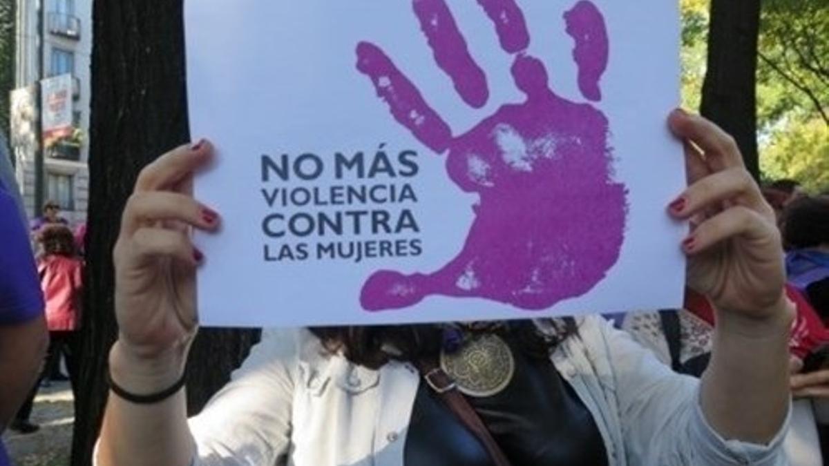 Una mujer porta un cartel contra la violencia de género